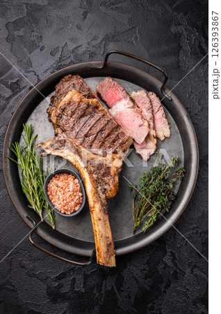 Roasted Tomahawk beef steak, roast dry aged rib eye with bone. black background. top view Roasted Tomahawk beef steak, roast dry aged rib eye with bone. black background. top view 126393867