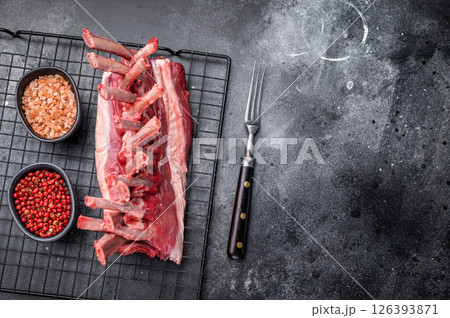 Raw rack of lamb, fresh mutton meat for chops cutlets. black background. top view Raw rack of lamb, fresh mutton meat for chops cutlets. black background. top view 126393871
