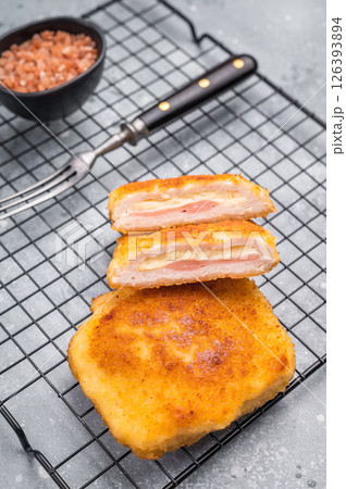 Fried Chicken cordon bleu cutlet with cheese and ham in breadcrumbs. grey background. top view Fried Chicken cordon bleu cutlet with cheese and ham in breadcrumbs. grey background. top view 126393894