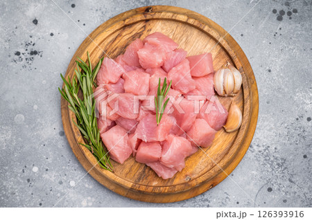 Diced raw turkey breast fillets, sliced poultry meat. grey background. top view Diced raw turkey breast fillets, sliced poultry meat. grey background. top view 126393916
