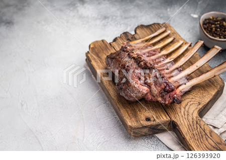 Grilled Rack of lamb, mutton meat chop steaks on wooden board. grey background. top view 126393920