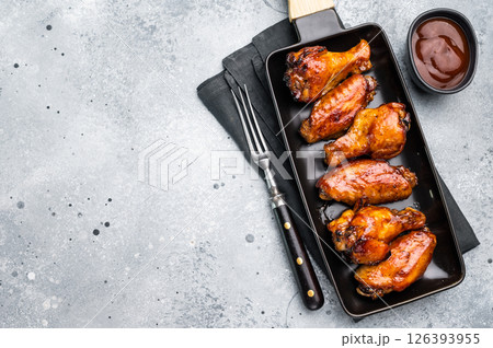 Juicy barbecue chicken wings, perfectly grilled and glazed, ideal for your next summer cookout or party. grey background. top view Juicy barbecue chicken wings, perfectly grilled and glazed, ideal for your next summer cookout or party. grey background. top view 126393955