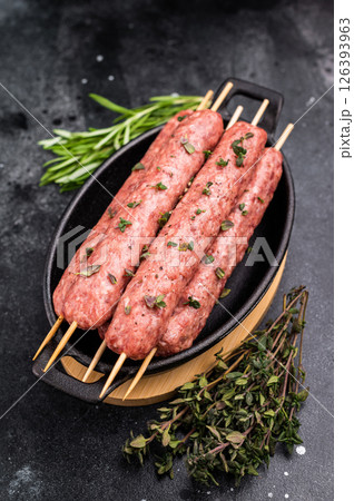Raw shish kebab, arabic kofta kofte kebab from mince lamb and beef meat on Skewer. black background. top view 126393963