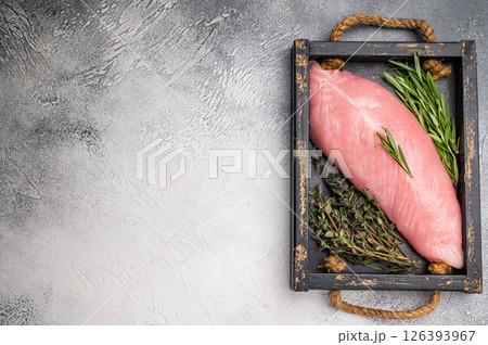 Raw poultry meat, fresh turkey breast fillet with herbs for cooking. grey background. top view 126393967