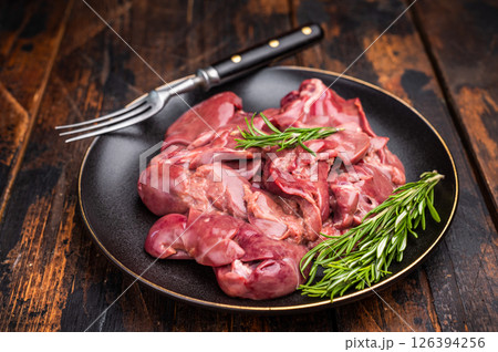 Raw chicken liver, featuring a glossy sheen and rich hue. A versatile ingredient that brings bold flavors to any culinary creation. wooden background. top view 126394256