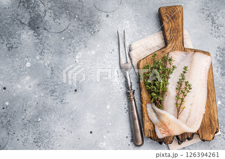 Fresh cod fish fillet, showcasing its delicate texture and pristine color, perfect for grilling or baking. grey background. top view 126394261