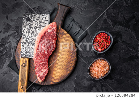 Freshly sourced picanha cut or rump cap steak, raw meat waiting to be transformed into a mouthwatering dish. black background. top view Freshly sourced picanha cut or rump cap steak, raw meat waiting to be transformed into a mouthwatering dish. black background. top view 126394284