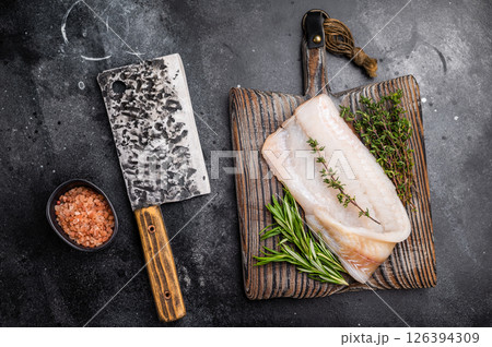Freshly cut cod fish fillet, highlighting its mild taste and versatility in various dishes. black background. top view 126394309