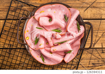 Mortadella sausage slices with pistachios for sandwiches in steel tray. wooden background. top view 126394311