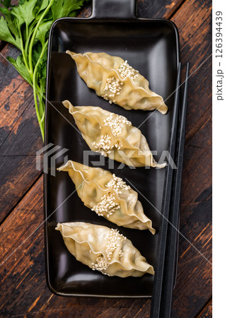 Steamed Korean Dumplings with pork meat and vegetables. wooden background. top view Steamed Korean Dumplings with pork meat and vegetables. wooden background. top view 126394439