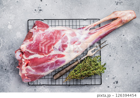 Raw whole goat leg, fresh meat. grey background. top view Raw whole goat leg, fresh meat. grey background. top view 126394454