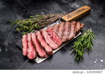 Savory shoulder steak Denver, beautifully cooked on the grill, highlighting its marbled texture and succulent taste. black background. top view 126394467
