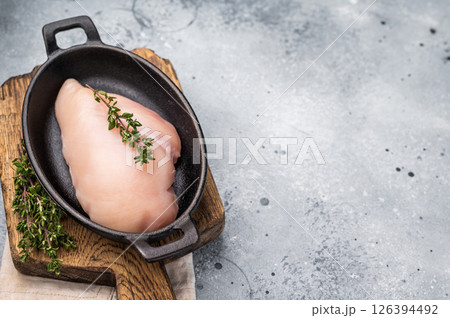Raw white meat cuts, showcasing their natural shape and quality. A staple ingredient for countless delicious dishes in any kitchen. grey background. top view Raw white meat cuts, showcasing their natural shape and quality. A staple ingredient for countless delicious dishes in any kitchen. grey background. top view 126394492