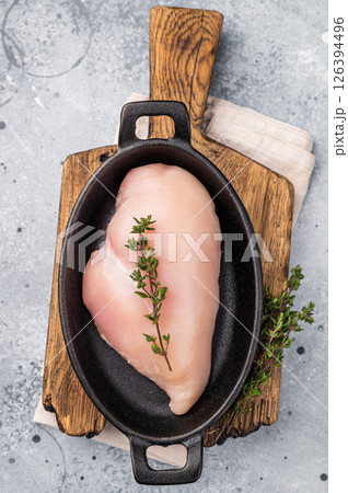 Raw white meat cuts, showcasing their natural shape and quality. A staple ingredient for countless delicious dishes in any kitchen. grey background. top view Raw white meat cuts, showcasing their natural shape and quality. A staple ingredient for countless delicious dishes in any kitchen. grey background. top view 126394496