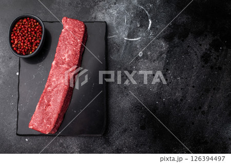 Exquisite raw wagyu beef, showcasing its rich marbling and vibrant color, perfect for gourmet dishes or high-end grilling experiences. black background. top view 126394497