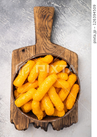 Irresistible Cheese puffs, cheese snacks bursting with bold flavors and a satisfying crunch. grey background. top view 126394509
