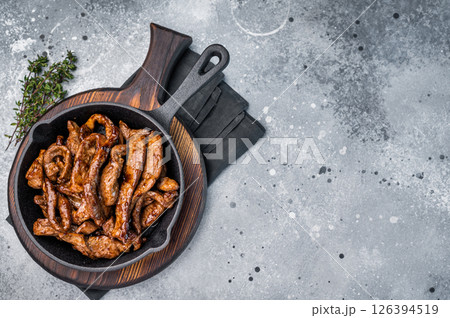 Delicious glazed teriyaki beef in a skillet. grey background. top view Delicious glazed teriyaki beef in a skillet. grey background. top view 126394519