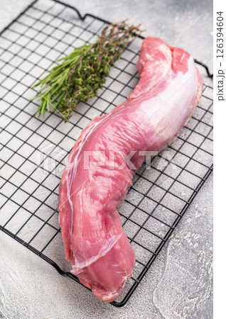 Uncooked pork loin fillet, raw tenderloin ready to be seasoned and transformed into a delicious centerpiece for dinner. white background. top view Uncooked pork loin fillet, raw tenderloin ready to be seasoned and transformed into a delicious centerpiece for dinner. white background. top view 126394604