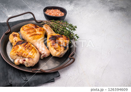 Juicy grilled chicken drumsticks, perfectly charred and bursting with flavor, ideal for a summer barbecue. grey background. top view Juicy grilled chicken drumsticks, perfectly charred and bursting with flavor, ideal for a summer barbecue. grey background. top view 126394609