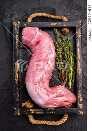Raw pork tender cut, tenderloin featuring a smooth texture, perfect for creating gourmet dishes at home. black background. top view 126394613