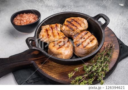 Juicy grilled pork medallions steaks, perfectly seared tenderloin meat for a flavorful bite, ideal for any gourmet meal. grey background. top view Juicy grilled pork medallions steaks, perfectly seared tenderloin meat for a flavorful bite, ideal for any gourmet meal. grey background. top view 126394621