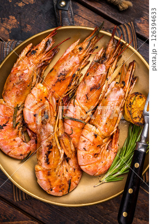 Grilled red Argentine shrimps, Prawns Langostino Austral on a plate with herbs. wooden background. top view 126394633