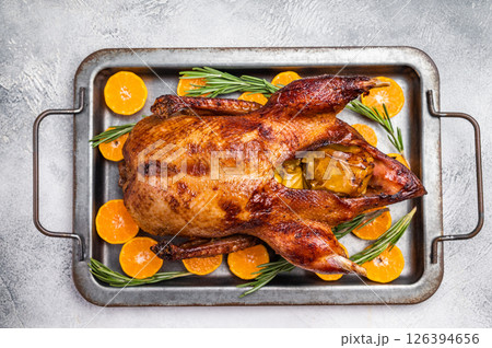 Baked whole duck with apples and herbs on steel tray. grey background. top view 126394656
