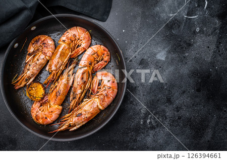Pan fried red Argentine shrimps, Prawns Langostino Austral with herbs. black background. top view Pan fried red Argentine shrimps, Prawns Langostino Austral with herbs. black background. top view 126394661