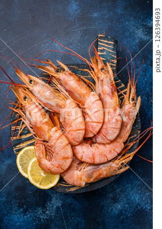 Ready for cooking Red Argentine shrimps, raw Prawns Langostino Austral on wooden board. blue background. top view Ready for cooking Red Argentine shrimps, raw Prawns Langostino Austral on wooden board. blue background. top view 126394693