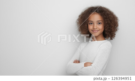 A professional studio portrait of a girl on a light plain background, expressing love and warmth with her arms wrapped around herself and a soft smile 126394951