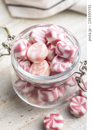 Colorful striped candies in jar on kitchen table. 126395591