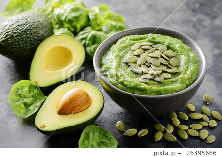 A green smoothie bowl with avocado slices, pumpkin seeds, and a touch of lime zest, presented with minimal props, concept of healthy eating A green smoothie bowl with avocado slices, pumpkin seeds, and a touch of lime zest, presented with minimal props, concept of healthy eating 126395666