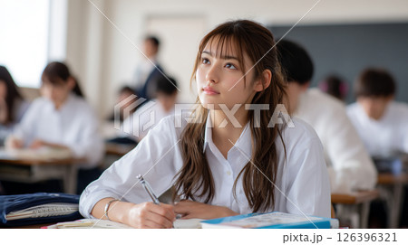 授業中に考えながらノートを取る女子高生 126396321