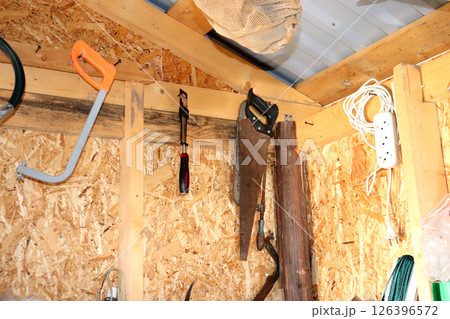 Tools and building materials on a wooden wall of a barn Tools and building materials on a wooden wall of a barn 126396572