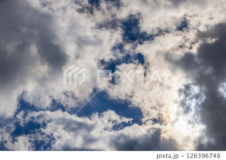 The sky is filled with clouds of varying shades, with sunlight filtering through gaps The sky is filled with clouds of varying shades, with sunlight filtering through gaps 126396748