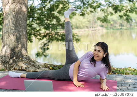 Wellness and Fitness. Woman stretching and practicing yoga by the lake. Wellness and Fitness. Woman stretching and practicing yoga by the lake. 126397072