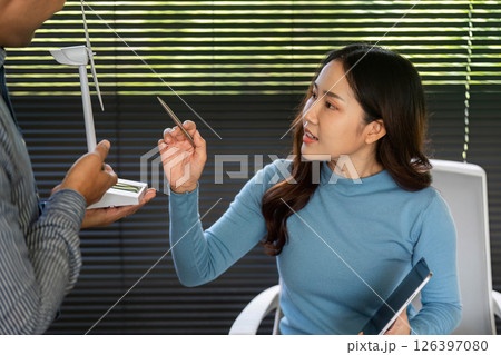 ESG Business Interaction. Professional woman explaining renewable energy concepts with wind turbine model. 126397080