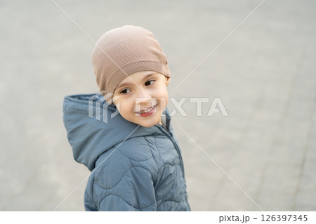 Happy smiling four year old toddler boy looking into the distance outdoors. Childhood and lifestyle concept. Portrait photo, close-up 126397345