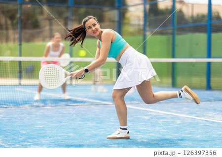 Woman standing on court and playing paddle tennis Woman standing on court and playing paddle tennis 126397356