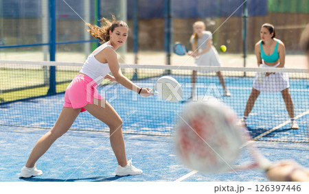 Woman playing with other paddle tennis players 126397446