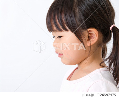 横顔で泣き出しそうな幼い女の子のポートレート(白背景) 横顔で泣き出しそうな幼い女の子のポートレート(白背景) 126397475