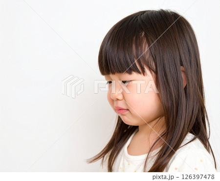 横顔で泣き出しそうな幼い女の子のポートレート（白背景） 126397478