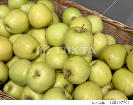 A vibrant and colorful display of fresh, crisp green apples organized neatly in a bustling market settings. Close-up. A vibrant and colorful display of fresh, crisp green apples organized neatly in a bustling market settings. Close-up. 126397705