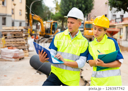 Two builders planning their work in construction plant Two builders planning their work in construction plant 126397742