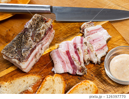 Traditional russian and ukrainian food, salted smoked pork bacon with horseradish on wooden cutting board Traditional russian and ukrainian food, salted smoked pork bacon with horseradish on wooden cutting board 126397770