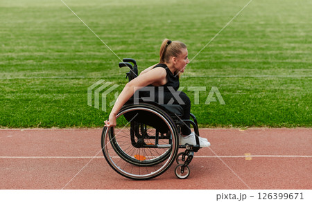 A woman with disablity driving a wheelchair on a track while preparing for the Paralympic Games A woman with disablity driving a wheelchair on a track while preparing for the Paralympic Games 126399671