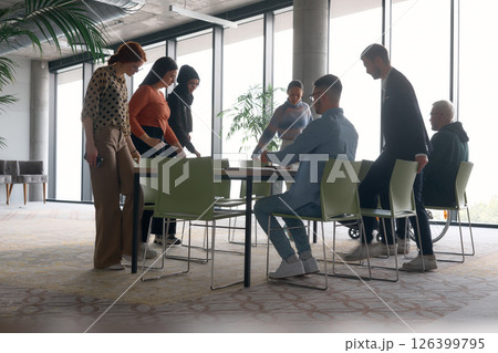 A diverse multiethnic business team engages in a collaborative meeting, discussing strategies and solutions in a modern office setting A diverse multiethnic business team engages in a collaborative meeting, discussing strategies and solutions in a modern office setting 126399795