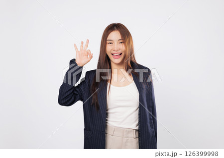 OK sign ok approval by a happy Asian woman smiling and gesturing success with her fingers isolated on a clean white background showing confidence and business agreement 126399998