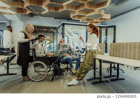 Young group of business people brainstorming together in a startup space, discussing business projects, investments, and solving challenges. 126400003