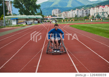 A person athlete with disability in a wheelchair racing on an outdoor track. 126400039